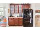 Kitchen area featuring dark wood cabinets, modern appliances, and a refrigerator, designed for functionality and style at 3132 W Meadowbend Dr, Monrovia, IN 46157
