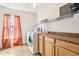 Bright laundry room with side-by-side washer and dryer, storage cabinets, and wire shelving for organization at 3132 W Meadowbend Dr, Monrovia, IN 46157