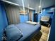 Blue bedroom with unique wall color, a bed, storage unit and beach-themed wall art at 318 Congress Ave, Indianapolis, IN 46208