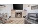 Living room fireplace with stone surround and decor, with view of gray reclining chair at 323 Norris Dr, Anderson, IN 46013