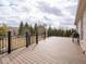 Expansive wooden deck with black metal railing, ideal for outdoor entertaining with views of mature trees and landscaping at 3791 Harveys Path, Greenwood, IN 46143
