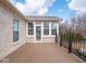Covered back deck area with many windows, perfect for enjoying outdoor living with views of mature trees and landscaping at 3791 Harveys Path, Greenwood, IN 46143