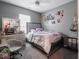 Well-lit bedroom with grey walls, a ceiling fan, and window illuminating the space at 3791 Harveys Path, Greenwood, IN 46143