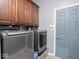 Laundry room featuring a gray front load washer and dryer with wood cabinets above at 3791 Harveys Path, Greenwood, IN 46143