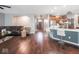 Bright open-concept room with hardwood flooring seamlessly leading into a modern kitchen with bar stool seating at 3791 Harveys Path, Greenwood, IN 46143