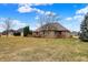 Expansive backyard view of a brick home and lush greenery under a partly cloudy sky at 3801 S Cedar Creek Ln, New Palestine, IN 46163