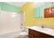 Fresh yellow and green bathroom with tub-shower combo and modern vanity at 3801 S Cedar Creek Ln, New Palestine, IN 46163
