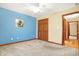 Bedroom with a blue accent wall, beige carpet flooring, and standard double closet at 3801 S Cedar Creek Ln, New Palestine, IN 46163