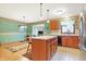 Open kitchen with wooden cabinets, tile floors, island, and seamless flow to dining area at 3801 S Cedar Creek Ln, New Palestine, IN 46163