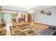 Open-concept living room with hardwood floors, rug, and seamless flow to the kitchen and dining area at 3801 S Cedar Creek Ln, New Palestine, IN 46163