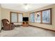 Cozy living room featuring a recliner, television, and large windows with wooded backyard views at 3801 S Cedar Creek Ln, New Palestine, IN 46163