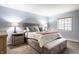 Comfortable bedroom features soft blue walls, a window for natural light, and a plush bed with stylish pillows at 3840 Knollton Rd # A, Indianapolis, IN 46228