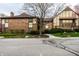 Brick townhouse features a walkway and a neatly landscaped front yard with mature trees and flowering shrubs at 3840 Knollton Rd # A, Indianapolis, IN 46228