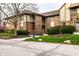 Brick townhouse features a walkway and a neatly landscaped front yard with mature trees and flowering shrubs at 3840 Knollton Rd # A, Indianapolis, IN 46228