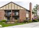 Exterior view of a two-story brick home with private patios and mature landscaping at 3840 Knollton Rd # A, Indianapolis, IN 46228