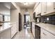 Kitchen with stainless steel appliances, white cabinets, and black subway tile backsplash at 3840 Knollton Rd # A, Indianapolis, IN 46228