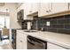 Clean kitchen with stainless steel appliances, white cabinets, and black subway tile backsplash at 3840 Knollton Rd # A, Indianapolis, IN 46228