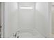 A bathroom showcases a drop-in tub with a window overhead and white walls at 4825 Topaz Pointe Blvd, Lawrence, IN 46235