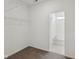 An empty carpeted walk-in closet with wire shelving and an adjoining bathroom with a tub at 4825 Topaz Pointe Blvd, Lawrence, IN 46235