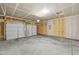 Spacious garage with a white garage door, high ceilings, and exposed framing at 4825 Topaz Pointe Blvd, Lawrence, IN 46235
