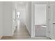 Hallway with light hardwood floors leading to bedroom with plush carpet at 4825 Topaz Pointe Blvd, Lawrence, IN 46235