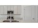 Modern kitchen featuring stainless steel appliances, white cabinets, and a bright quartz countertop at 4825 Topaz Pointe Blvd, Lawrence, IN 46235