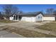 View of the attached garage with additional door and driveway in a quiet neighborhood at 504 Iroquois Dr, Anderson, IN 46012