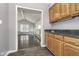 A wet bar area featuring granite countertops and wooden cabinets, connecting to a living space with hardwood floors at 5214 Woodfield Dr, Carmel, IN 46033