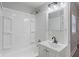 Bright bathroom featuring a shower-tub combo, white vanity with black faucet, and modern lighting at 569 N Tacoma Ave, Indianapolis, IN 46201
