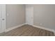Bedroom featuring wood-look flooring, neutral paint, white trim and baseboard, and a white door at 569 N Tacoma Ave, Indianapolis, IN 46201