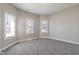 This bedroom has two bright windows, gray carpet, neutral walls, and white trim at 569 N Tacoma Ave, Indianapolis, IN 46201
