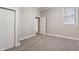 Bedroom featuring neutral walls, gray carpet, white trim and two doors, and a window at 569 N Tacoma Ave, Indianapolis, IN 46201