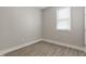 Cozy bedroom features wood-look flooring, neutral paint, white trim, and a window with blinds at 569 N Tacoma Ave, Indianapolis, IN 46201