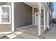 Inviting front porch with gray siding, white trim, and the house number displayed at 569 N Tacoma Ave, Indianapolis, IN 46201