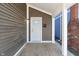 Inviting front porch with gray siding, white trim, and a white front door with glass at 569 N Tacoma Ave, Indianapolis, IN 46201