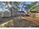 Backyard with wooden deck, mature trees, and a partially fenced yard at 5935 Compton St, Indianapolis, IN 46220