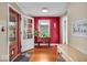 Bright entryway with hardwood floors, red accent wall, and a view of the front door, providing a warm welcome at 5935 Compton St, Indianapolis, IN 46220