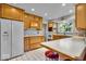 Bright kitchen with wood cabinets, white appliances, a breakfast bar and tile floors at 5935 Compton St, Indianapolis, IN 46220