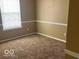 Cozy bedroom features neutral carpet, freshly painted walls and a large window at 6030 Tybalt Cir, Indianapolis, IN 46254