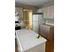 Kitchen with island, white cabinets, and white refrigerator at 6030 Tybalt Cir, Indianapolis, IN 46254