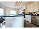 Gourmet kitchen island with cooktop, stainless appliances, and bright white cabinets at 6416 E Urmeyville Rd, Franklin, IN 46131