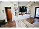 Gathering room featuring custom built-ins, TV, and views to the front entry and wood floors at 6416 E Urmeyville Rd, Franklin, IN 46131