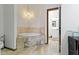 The bathroom offers a soaking tub with stone surround and stylish lighting fixture at 6454 Bay Harbor Ln, Indianapolis, IN 46254