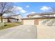 Attached two-car garage with brick facade and concrete driveway under a bright blue, partly cloudy sky at 6454 Bay Harbor Ln, Indianapolis, IN 46254