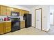 Kitchen featuring wood cabinets, appliances, and a nearby pantry, offering functionality for meal preparation and storage at 6454 Bay Harbor Ln, Indianapolis, IN 46254