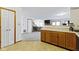 Open-concept kitchen with wood cabinets, adjoining living area, and nearby pantry for seamless living and entertaining at 6454 Bay Harbor Ln, Indianapolis, IN 46254