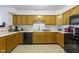 Well-lit kitchen featuring wood cabinets, black appliances, and light countertops at 6454 Bay Harbor Ln, Indianapolis, IN 46254