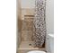 Shower stall with stone-look tile and neutral shower curtain at 6454 Bay Harbor Ln, Indianapolis, IN 46254