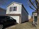 View of the side of a two story home with white siding and a brick accent around a garage door at , Indianapolis, IN 46217
