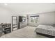 A well-lit bedroom features neutral carpet, a dresser, a mirror, and a large window at 6713 Cardiff Dr, McCordsville, IN 46055